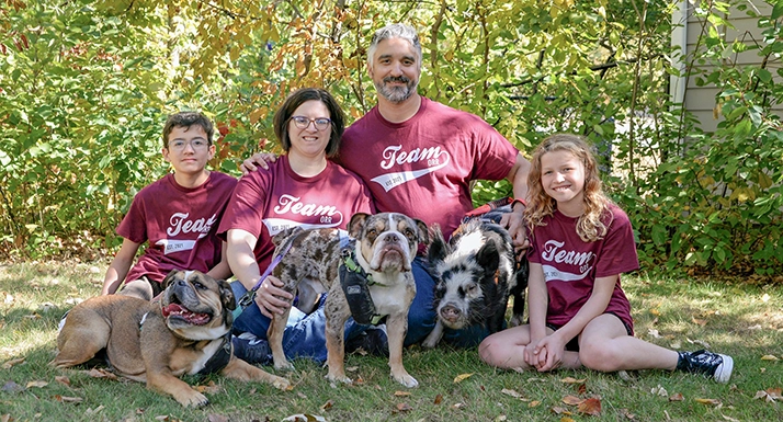 Kayla Orr smiling outside.. with her family and pets